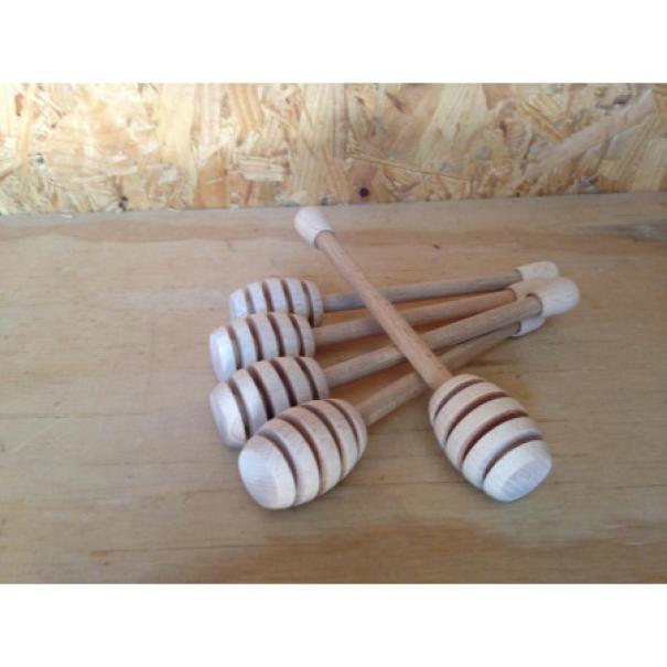 prese di prendimiele in legno disposti su piano di legno per miele