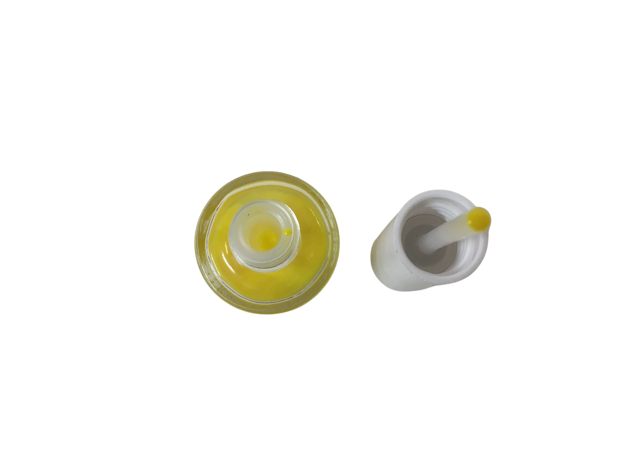 Vista dall'alto del flacone di smalto giallo e tappo con tampone