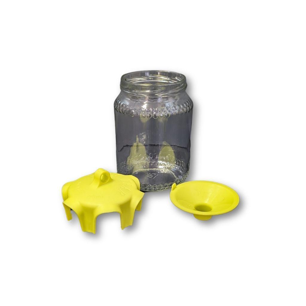 Dettaglio vaso in vetro con imbuto interno e coperchio giallo smontati